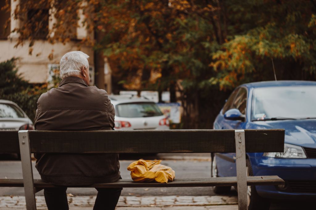 Man sitting on bench waiting. Image by mykyta-martynenko on Unsplash.